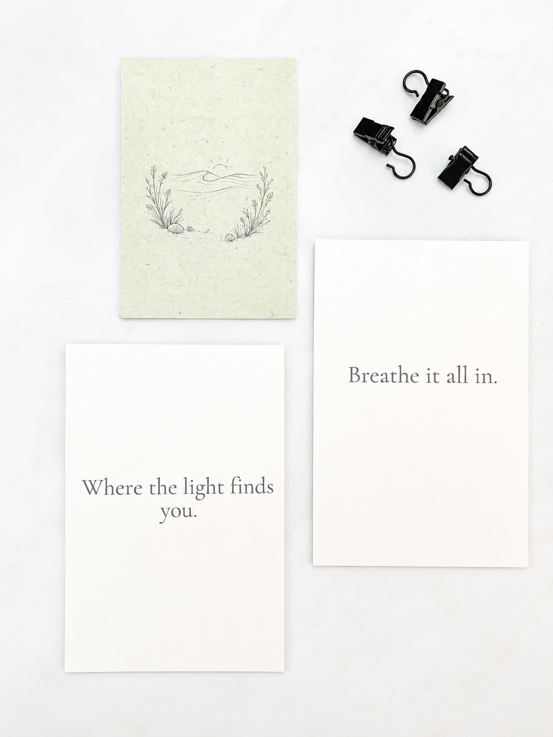 3 prints with image and quotes and 3 clips on a white surface.