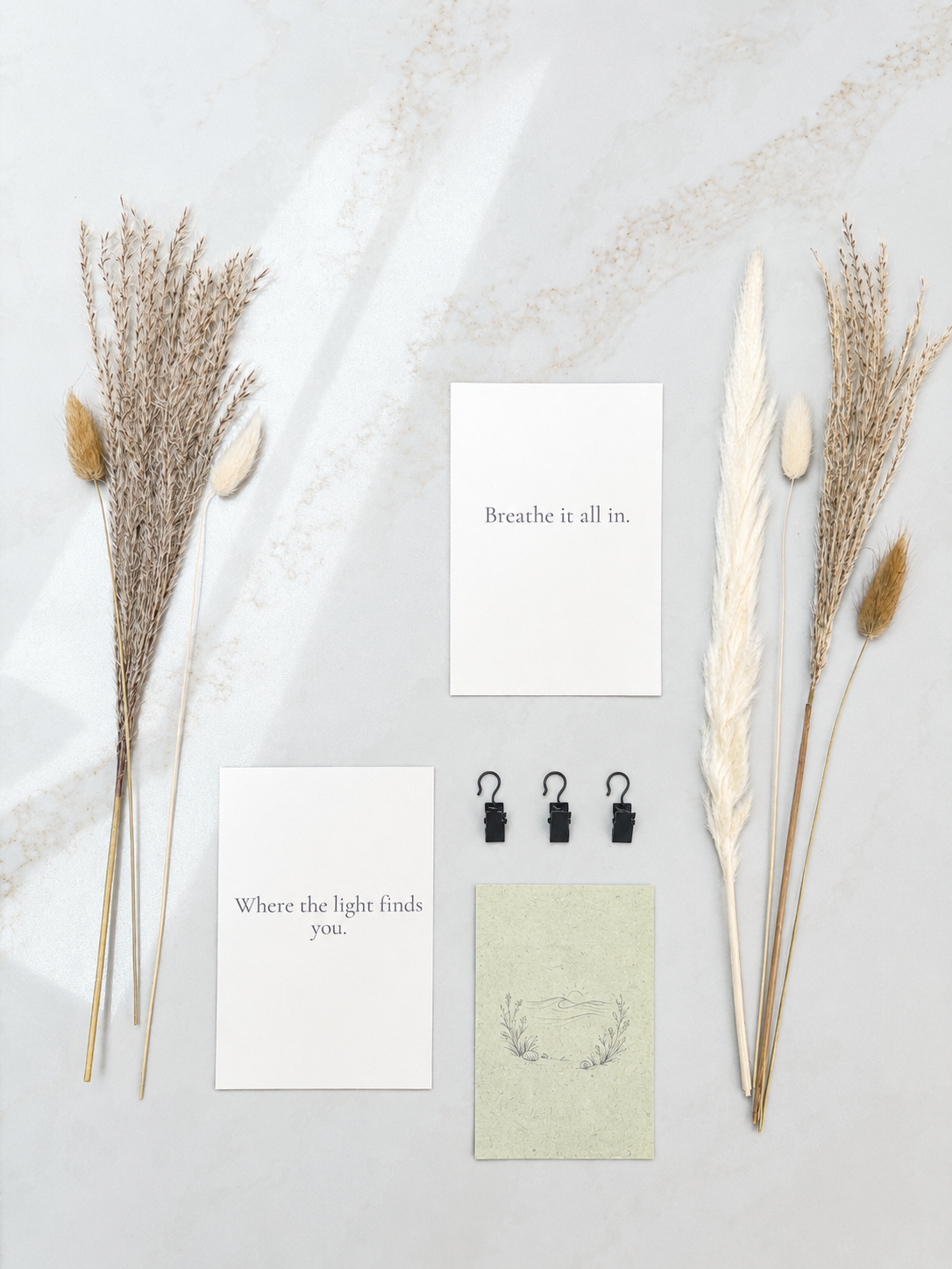 Decorative elements including dried plants and motivational cards on a light background